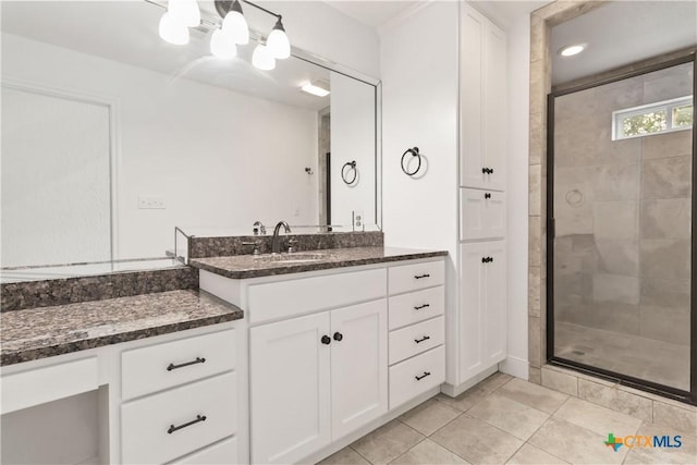 bathroom with tile patterned floors, vanity, and an enclosed shower