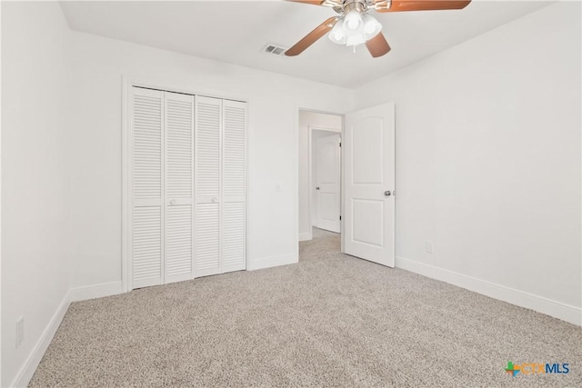 unfurnished bedroom with ceiling fan, a closet, and light carpet