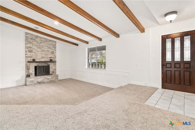 carpeted foyer entrance featuring lofted ceiling with beams and a fireplace