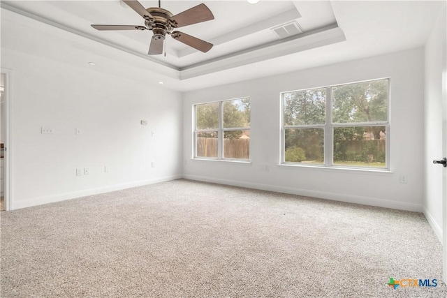 carpeted empty room featuring a raised ceiling and ceiling fan