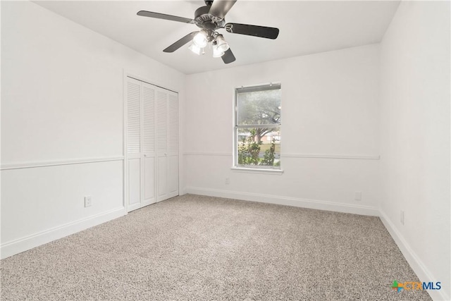 carpeted spare room with ceiling fan