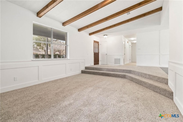 carpeted spare room featuring vaulted ceiling with beams