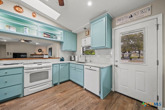 kitchen with a sink, tasteful backsplash, white appliances, blue cabinetry, and ceiling fan