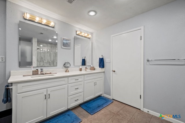 bathroom featuring tile patterned flooring, vanity, and walk in shower