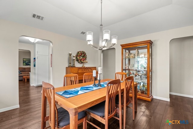 dining room featuring dark hardwood / wood-style flooring, a notable chandelier, and vaulted ceiling