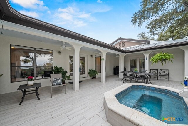 view of patio / terrace with an in ground hot tub and ceiling fan