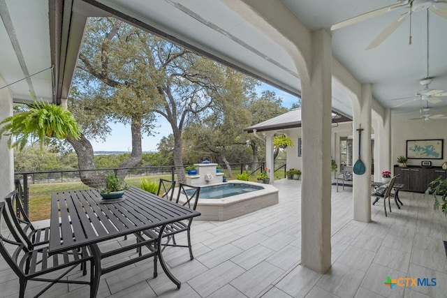 view of patio featuring outdoor dining area, fence, a ceiling fan, and an outdoor hot tub