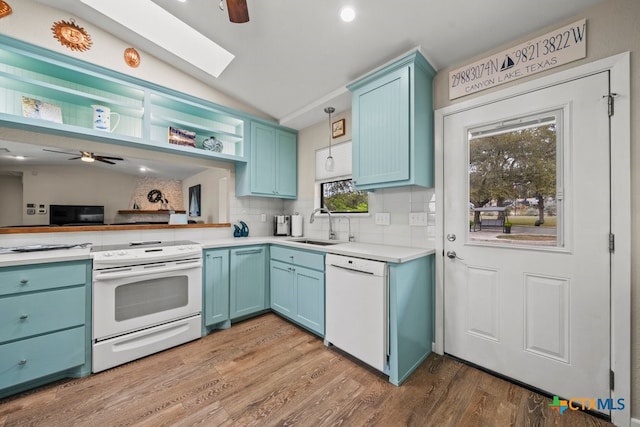 kitchen featuring lofted ceiling, sink, white appliances, tasteful backsplash, and pendant lighting