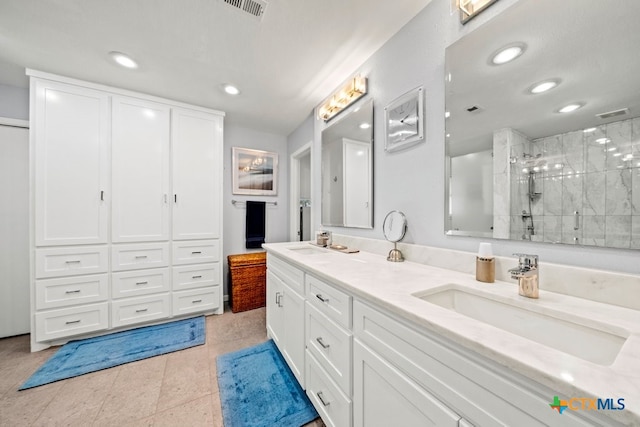 bathroom with an enclosed shower, vanity, and tile patterned floors