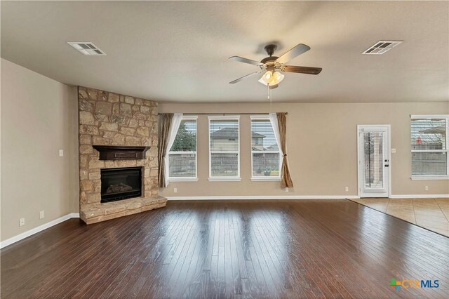 unfurnished living room with visible vents, plenty of natural light, and hardwood / wood-style floors