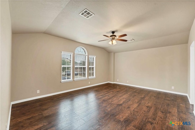 unfurnished room featuring visible vents, dark wood-type flooring, and vaulted ceiling