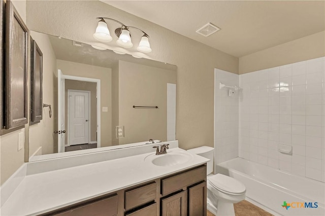 bathroom with visible vents, toilet, bathtub / shower combination, a textured wall, and vanity