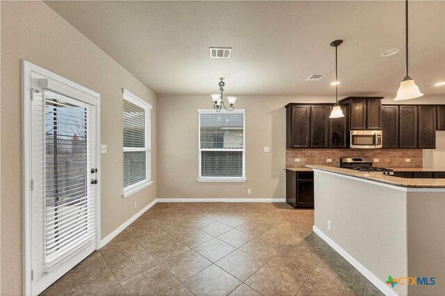 kitchen with visible vents, backsplash, stainless steel appliances, dark brown cabinetry, and hanging light fixtures