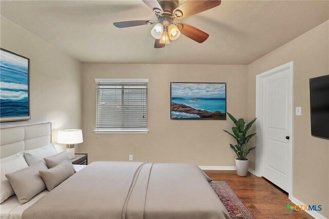 bedroom with baseboards, wood finished floors, and a ceiling fan