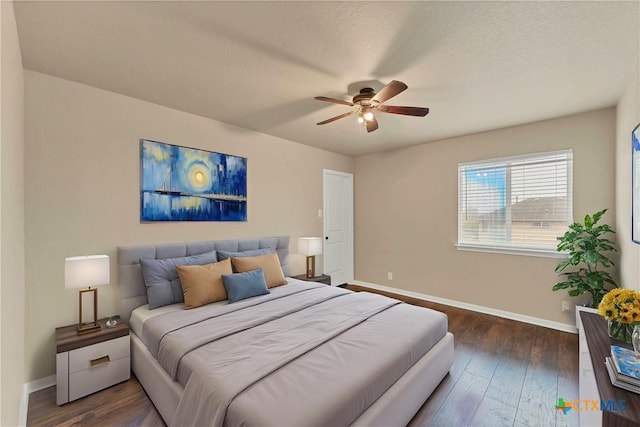 bedroom with baseboards, dark wood-style floors, and a ceiling fan