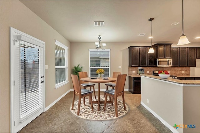 dining area featuring an inviting chandelier, light tile patterned floors, baseboards, and visible vents