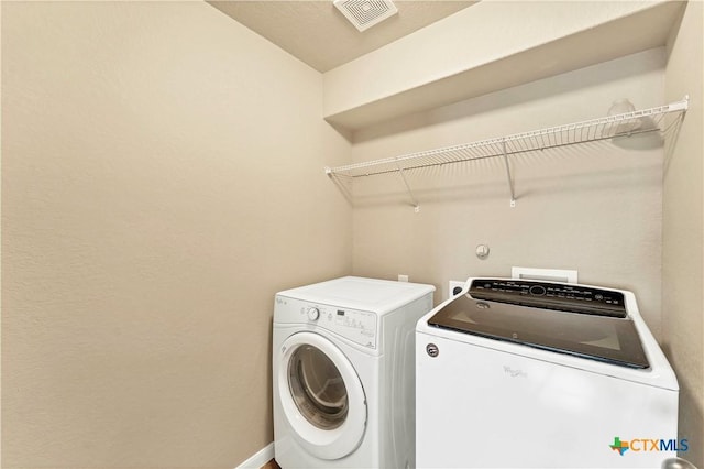 washroom with washer and clothes dryer, laundry area, baseboards, and visible vents