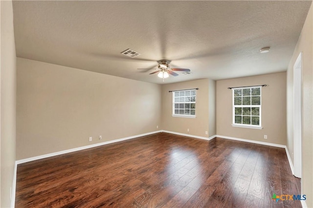 unfurnished room featuring visible vents, baseboards, a ceiling fan, and dark wood-style flooring