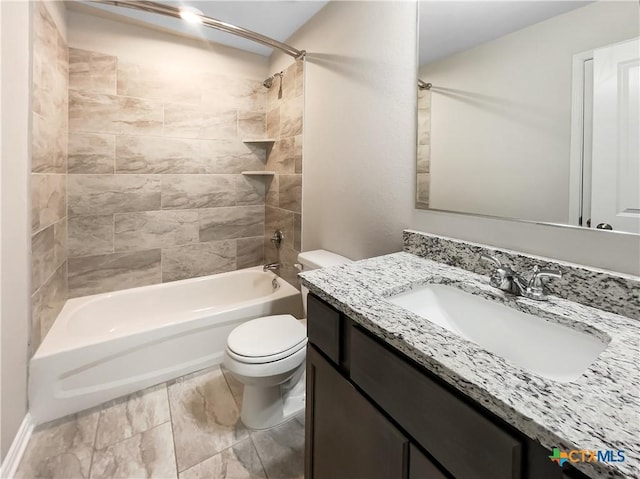 full bathroom featuring vanity, tiled shower / bath combo, and toilet