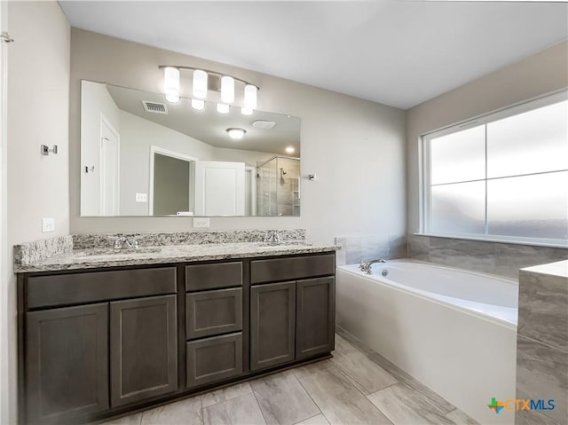 bathroom featuring vanity and separate shower and tub