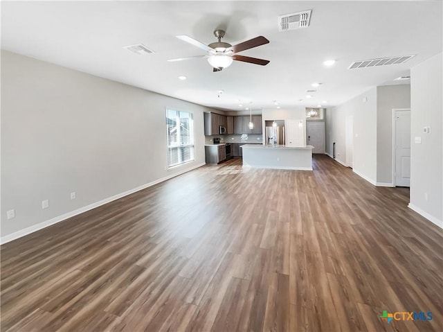 unfurnished living room featuring dark hardwood / wood-style flooring and ceiling fan