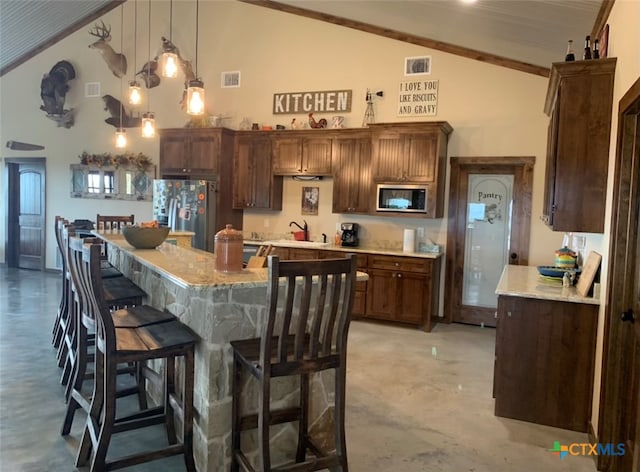 kitchen featuring pendant lighting, high vaulted ceiling, stainless steel appliances, and a center island