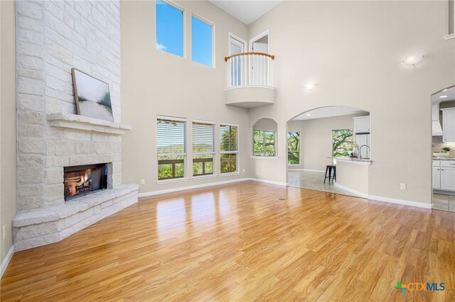 171 Clear Rdg, New Braunfels, TX 78132 - unfurnished living room featuring a high ceiling, light wood-style flooring, baseboards, and a fireplace