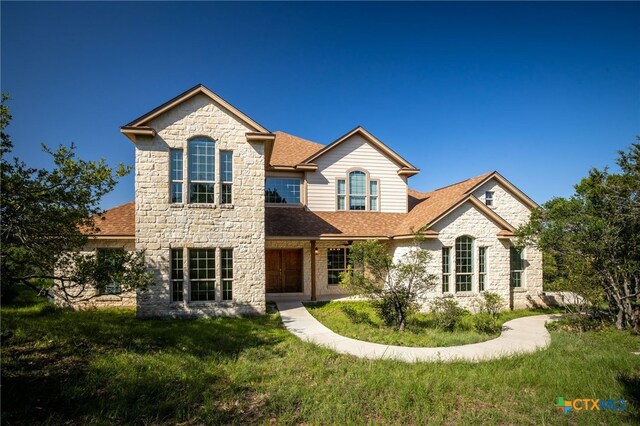171 Clear Rdg, New Braunfels, TX 78132 - view of front facade with stone siding, a shingled roof, and a front lawn