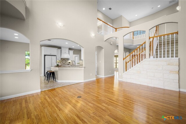 171 Clear Rdg, New Braunfels, TX 78132 - unfurnished living room with stairs, light wood finished floors, baseboards, and visible vents