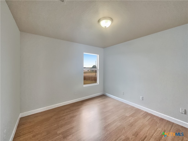 spare room with hardwood / wood-style flooring and a textured ceiling