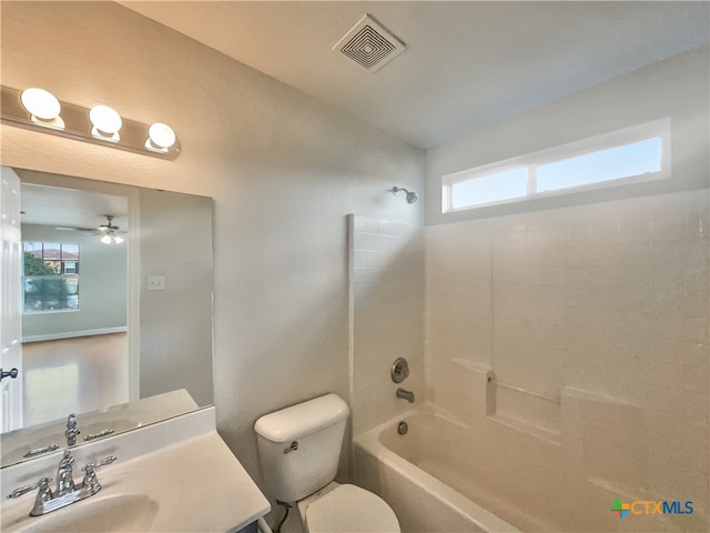 full bathroom featuring toilet, vanity, tiled shower / bath, and ceiling fan