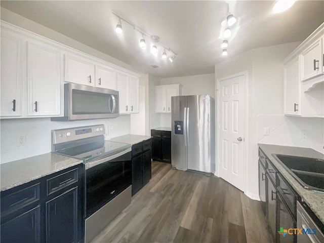 kitchen featuring stainless steel appliances, sink, light stone countertops, white cabinets, and dark hardwood / wood-style flooring