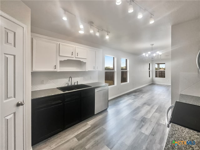 kitchen with a notable chandelier, sink, stainless steel dishwasher, white cabinetry, and light wood-type flooring