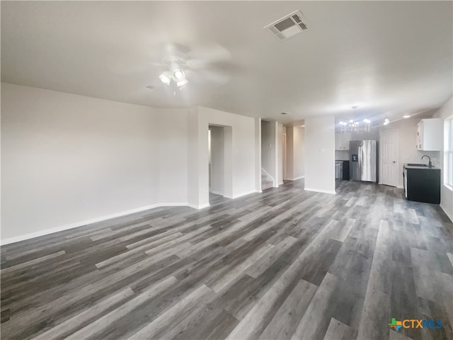 unfurnished living room with dark wood-type flooring, ceiling fan, and sink