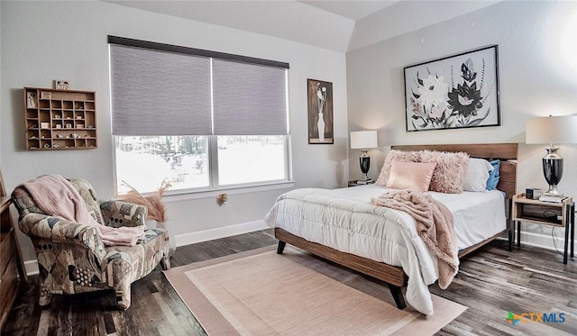 bedroom with dark hardwood / wood-style flooring and vaulted ceiling