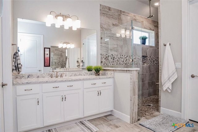 bathroom featuring vanity, tile patterned flooring, and tiled shower