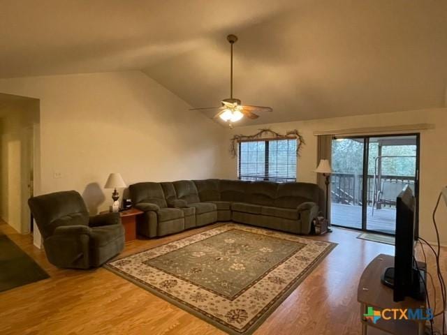 living area with lofted ceiling, wood finished floors, and a ceiling fan