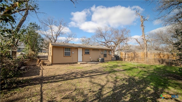 back of property featuring central AC unit and a yard