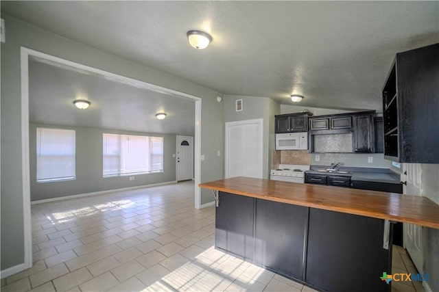 kitchen featuring butcher block counters, white appliances, light tile patterned floors, a breakfast bar area, and lofted ceiling