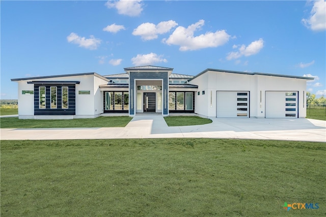 view of front of home with a front yard and a garage