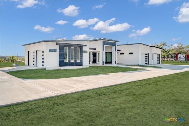 view of front of property featuring a garage and a front lawn