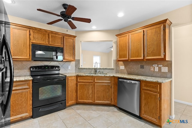 kitchen featuring light stone countertops, sink, ceiling fan, decorative backsplash, and black appliances