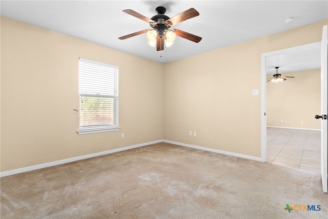 carpeted spare room with ceiling fan