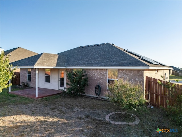 back of house featuring solar panels and a patio area