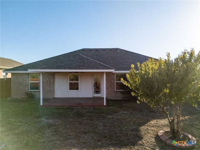 rear view of house with a lawn and a patio area