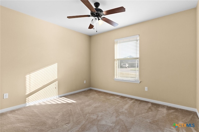 carpeted spare room with ceiling fan