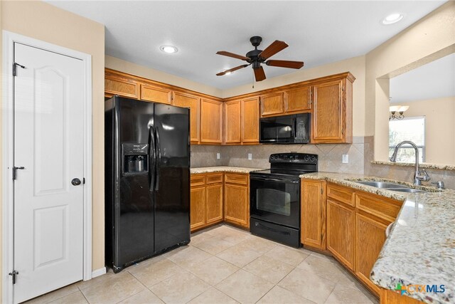 kitchen featuring light stone countertops, tasteful backsplash, ceiling fan, sink, and black appliances