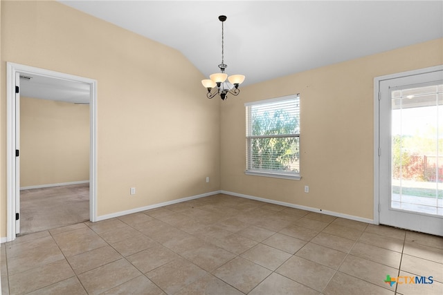 tiled empty room featuring vaulted ceiling and a notable chandelier