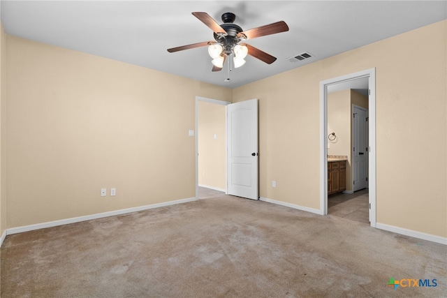 unfurnished bedroom with connected bathroom, ceiling fan, and light colored carpet