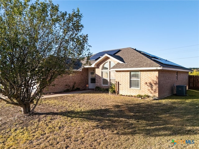 exterior space with solar panels, central air condition unit, and a yard